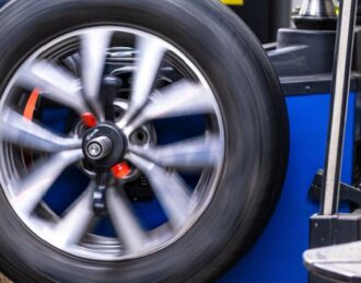 Wheel and tire assembly being balanced on a professional tire balancing machine in Mono, ON