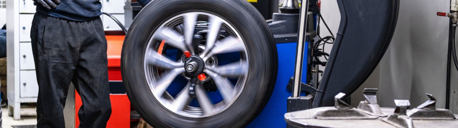 Wheel and tire assembly being balanced on a professional tire balancing machine in Mono, ON